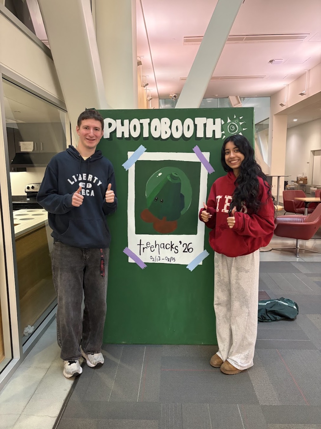 The finished photo booth at TreeHacks 2026, beside its hand-painted green sign